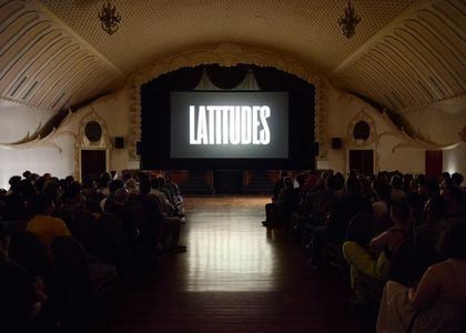 Image of cinema theatre with 'Latitudes' on the screen